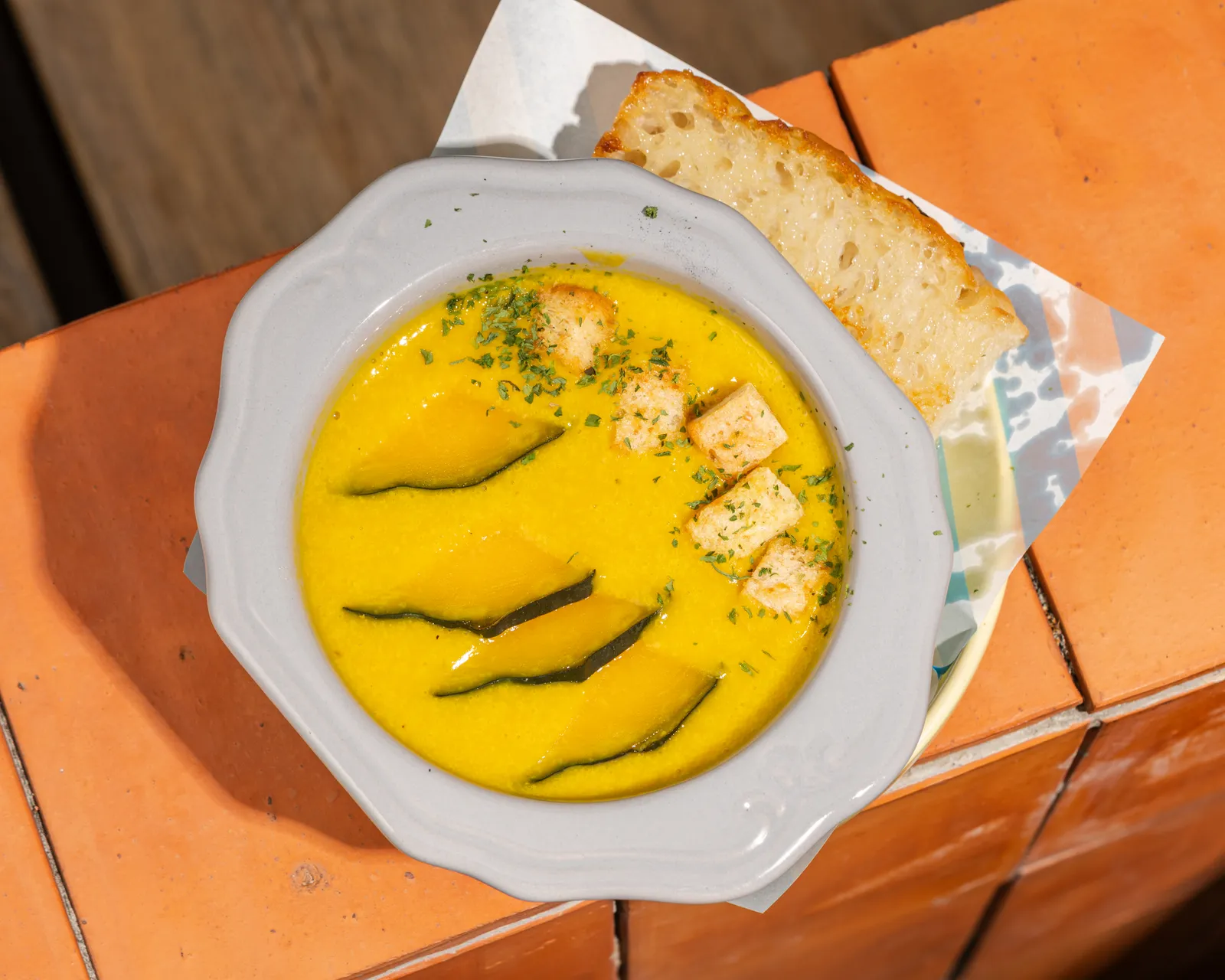 Bowl of pumpkin soup with crusty bread at Kynd Kulture